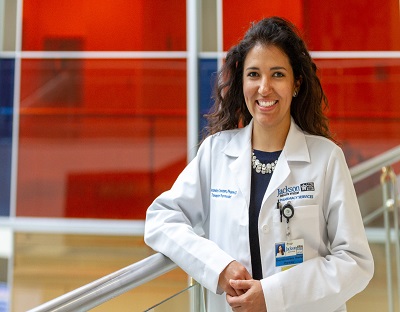 Female pharmacist smiling near a staircase