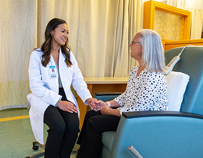 A female pharmacist speaks with an elderly patient