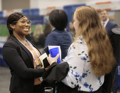 Two Midyear meeting attendees talking to each other