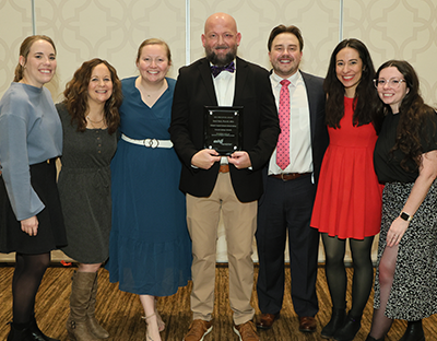 2024 Pharmacy Residency Excellence Preceptor Awardee is in the center of a group photo with six other people