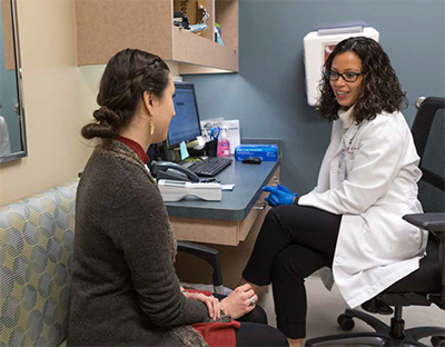 Female pharmacist counsels a female patient at a desk